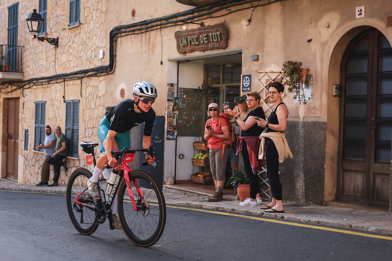 Victoria Stansfield riding through a village past spectators