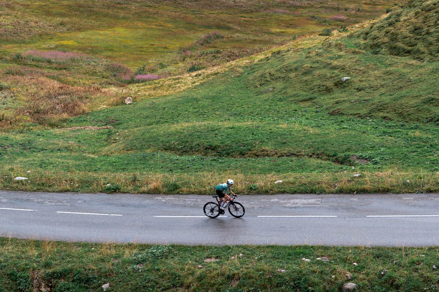 Aerial view of a rider and support vehicle on an alpine road